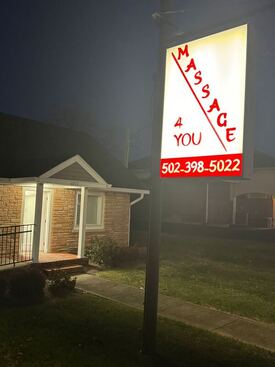 Picture of Massage 4 You front of building in evening with sign turned on call 502-398-5022